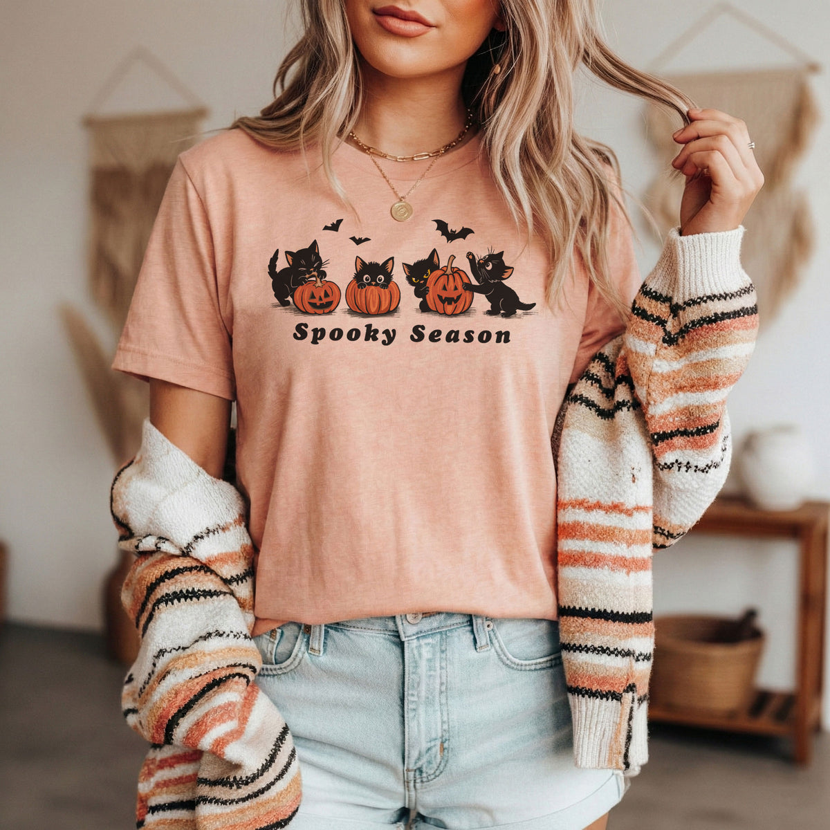 Woman wearing Spooky Season Halloween cat t-shirt in Heather Peach